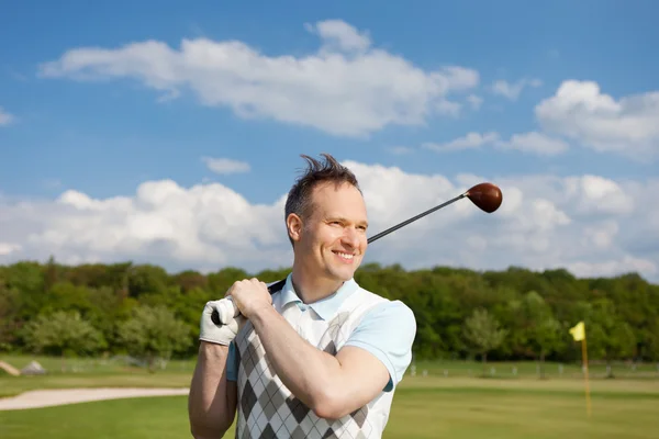 Человек держит гольф-клуб, пока смотрит в сторону — стоковое фото
