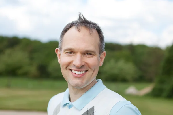 Uomo maturo sorridente al campo da golf — Foto Stock