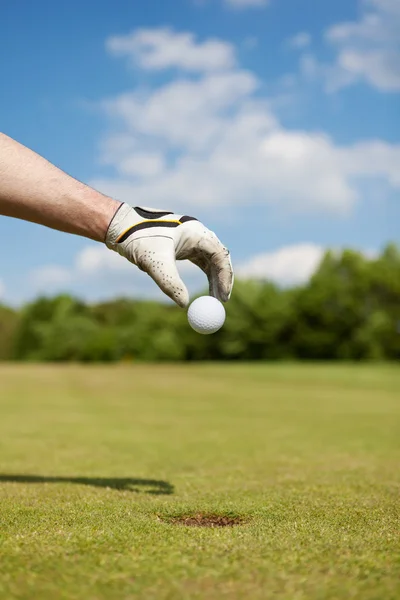 Golfista mettendo pallina da golf a mano — Foto Stock