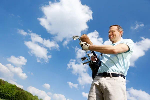 Homem removendo clube de golfe contra o céu — Fotografia de Stock