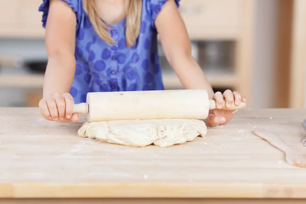 Маленькая девочка разворачивает тесто — стоковое фото