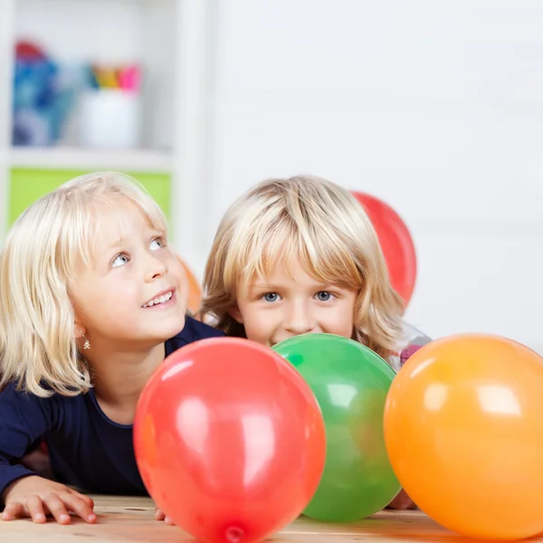 Девушки с разноцветными воздушными шарами дома — стоковое фото