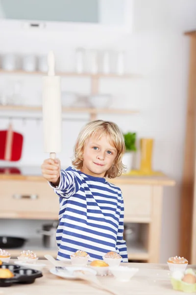 Girl playing in the kitchen holding a rolling-pin — Stock Photo, Image