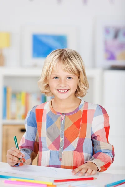 Kleine meisje glimlachend en tekenen van een afbeelding — Stockfoto