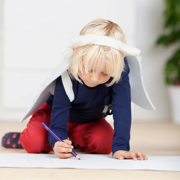 Young girl in angel wings drawing on the floor — Stock Photo, Image