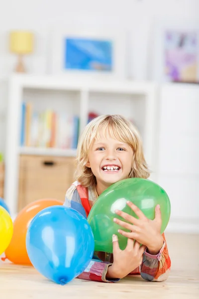Upphetsad liten blond flicka med party ballonger — Stockfoto