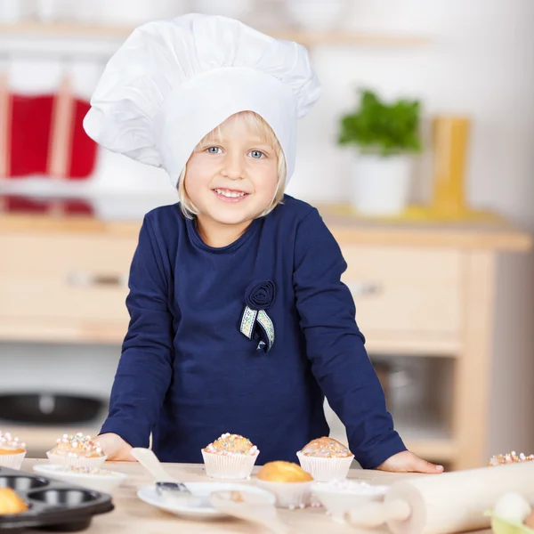 Söt liten blond flicka i en kockar toque — Stockfoto