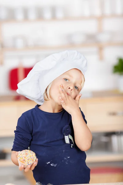 Small chef licking her fingers — Stock Photo, Image