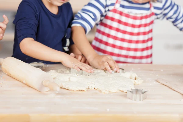 Meisjes met behulp van scharen op deeg op aanrecht — Stockfoto