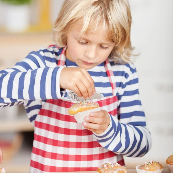 Ragazza aggiungendo Sprinkles su Cupcake — Foto Stock