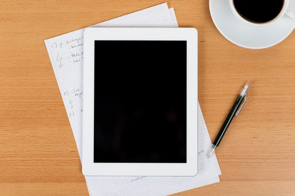 Digital tablet över ett skrivbord med anteckningar och kaffe — Stockfoto