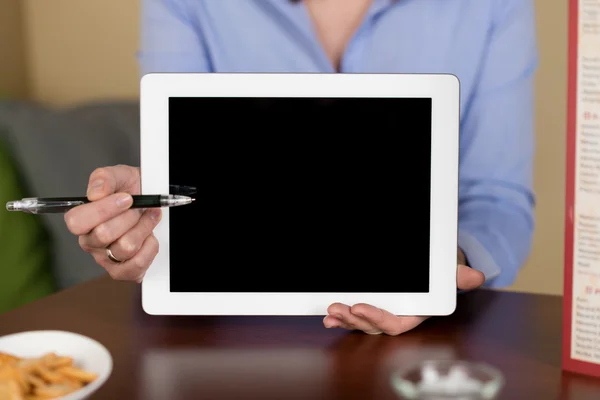 Frau zeigt auf leeres Tablet-Display — Stockfoto