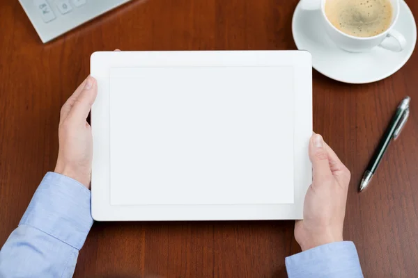 Business person holding a tablet over a desk — Stock Photo, Image