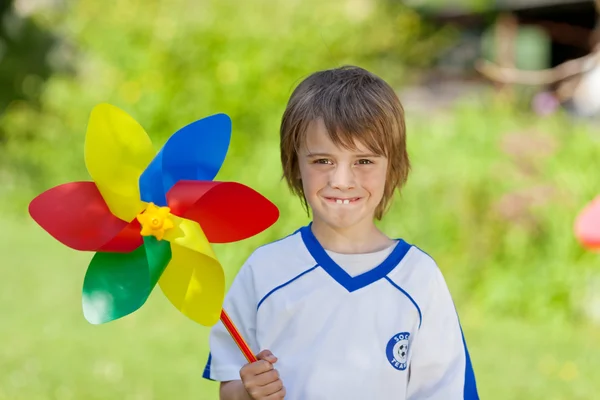 Rapaz segurando Pinwheel no quintal — Fotografia de Stock