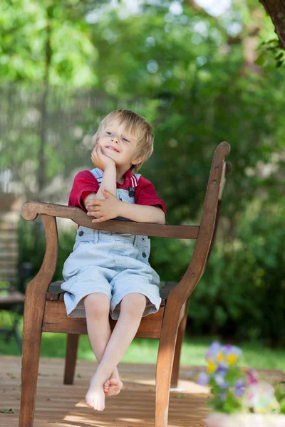 Sweet little boy on a wooden bench — Stock Photo, Image