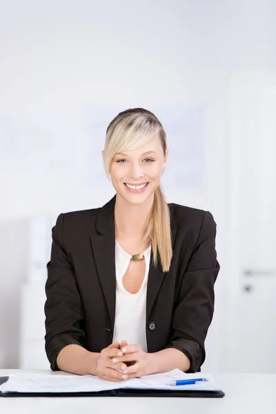 Mulher de negócios bonita sentado em sua mesa de escritório — Fotografia de Stock