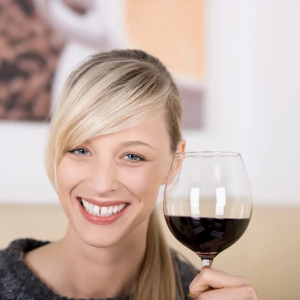 Femme blonde souriante trinquant avec un verre de vin — Photo