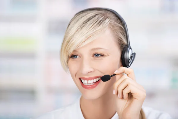 Friendly female pharmacist using headsets — Stock Photo, Image