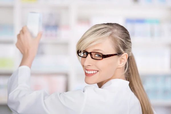 Friendly female pharmacist stores the medicines — Stock Photo, Image