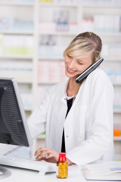 Lachende aantrekkelijke apotheker praten aan de telefoon — Stockfoto