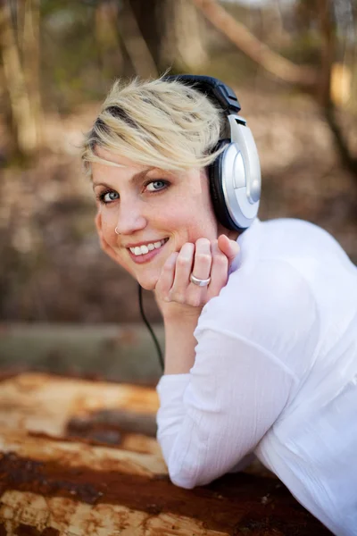 Rückansicht einer lächelnden Frau mit Kopfhörern im Freien — Stockfoto