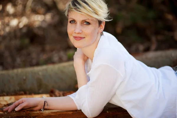 Young Blond Woman Lying On Logs — Stock Photo, Image