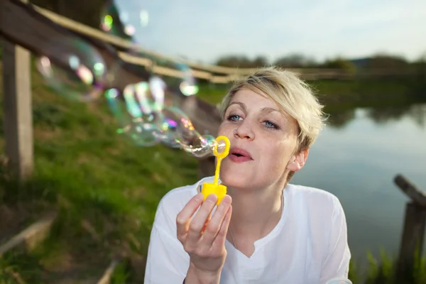 Jeune femme faisant des bulles de savon — Photo