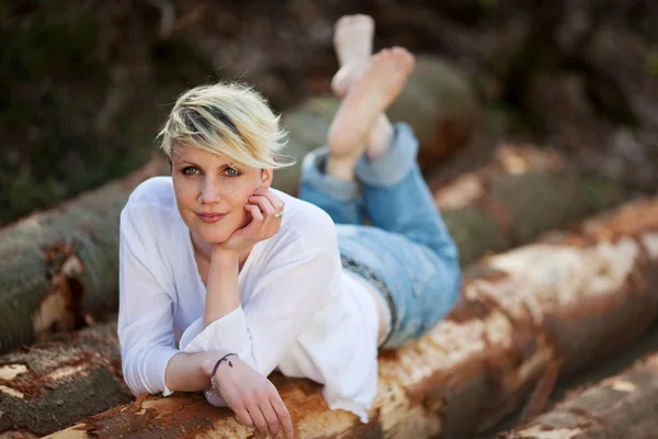 Blond Woman Lying On Logs — Stock Photo, Image