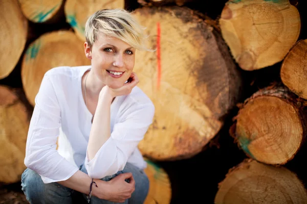 Retrato de mujer sonriendo contra troncos —  Fotos de Stock