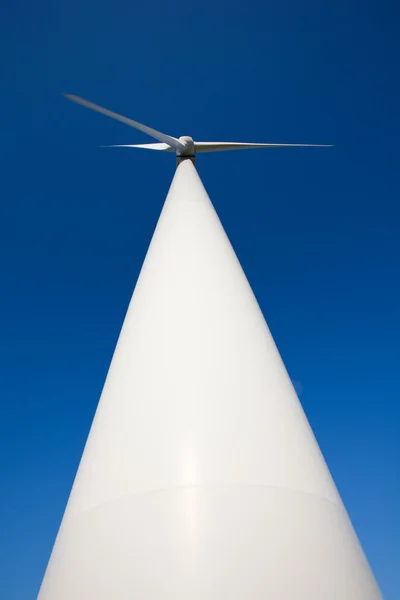 Låg vinkel syn på vindkraftverk mot blå himmel — Stockfoto