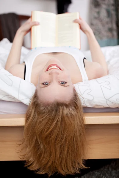 Mujer sosteniendo libro mientras está acostado en la cama — Foto de Stock