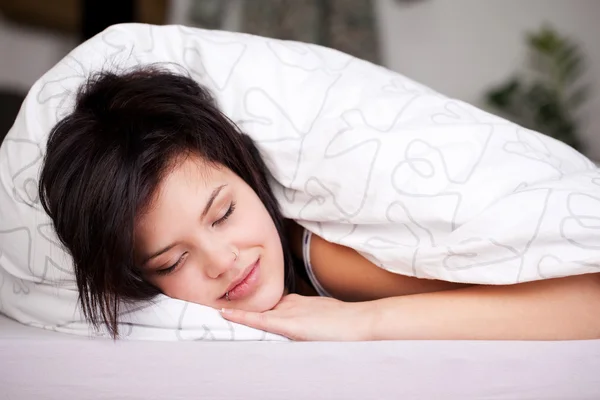 Sorridente bella ragazza addormentata a letto — Foto Stock