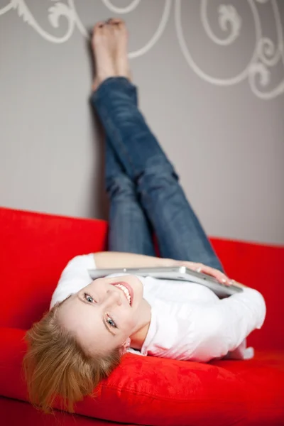 Kvinna med laptop liggande på soffan — Stockfoto