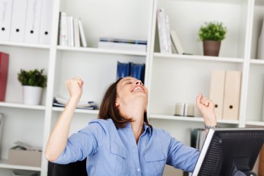 Businesswoman rejoicing in her office clipart