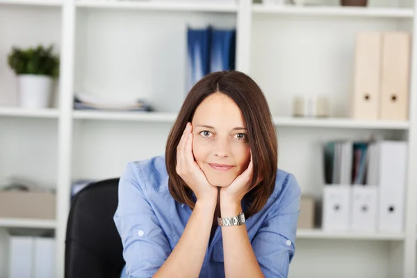 Säker affärskvinna med händerna på kinderna i office — Stockfoto