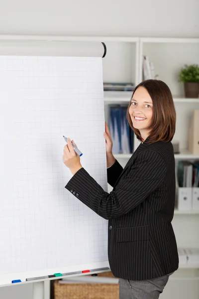 Ung affärskvinna skriva på en blank blädderblock — Stockfoto
