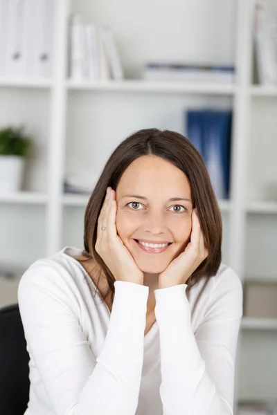 Empresaria con las manos en las mejillas en la oficina — Foto de Stock