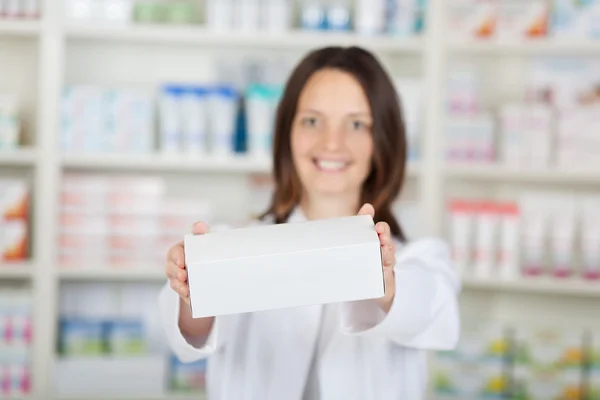 Farmacêutica Feminina Segurando Caixa Branca na Farmácia — Fotografia de Stock