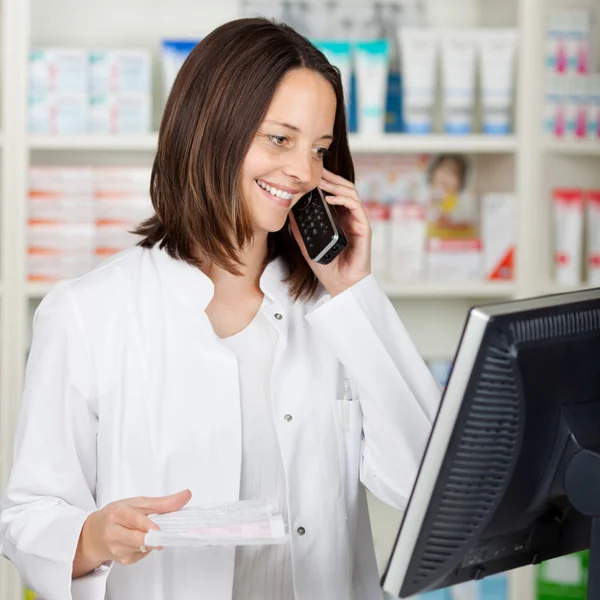 Pharmacist Using Cordless Phone While Looking At Computer — Stock Photo, Image