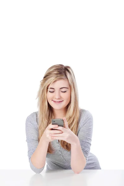 Симпатичная подросток занята сообщениями на смартфоне — стоковое фото