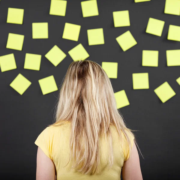 Femme devant tableau noir avec des notes collantes — Photo