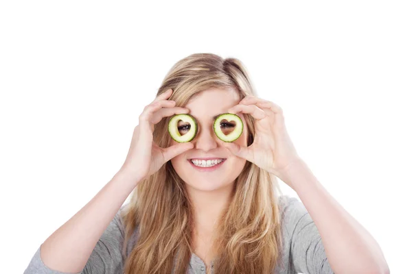 Teenage girl looking through cucumbers — Stock Photo, Image