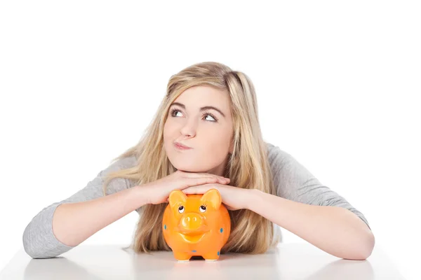 Menina adolescente bonito posando com porquinho banco — Fotografia de Stock