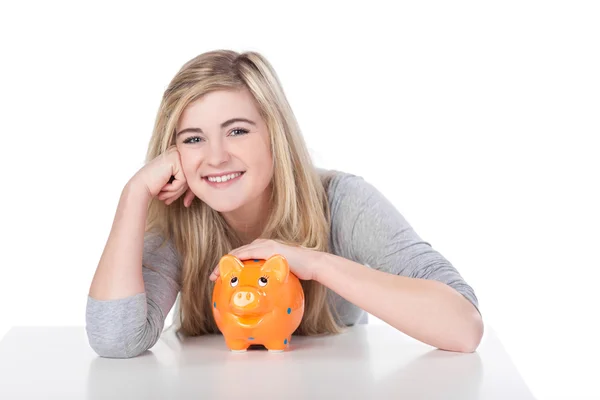 Cute teenage girl smiling while holding piggy bank — Stock Photo, Image