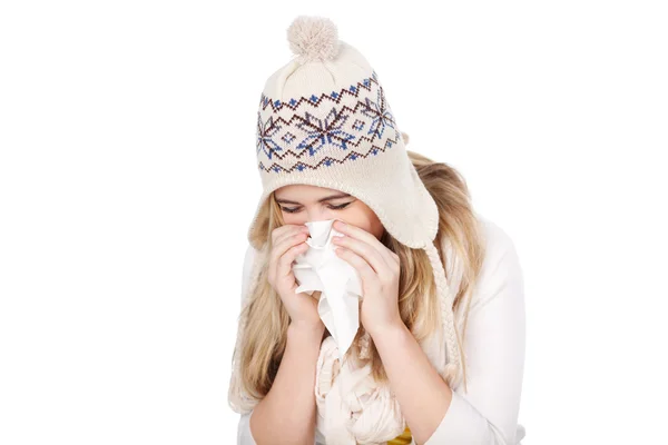 Adolescent fille dans tricoté chapeau souffler son nez — Photo