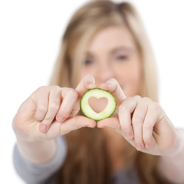 Genç kızın kalbini salatalık dilim şeklinde tutarak bulanık — Stok fotoğraf