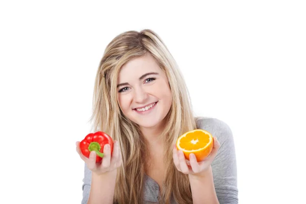 Lächelndes Teenie-Mädchen mit Paprika und halb Orange — Stockfoto