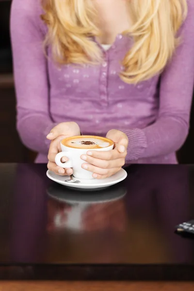 Vrouw met koffie beker aan tafel in café — Stockfoto