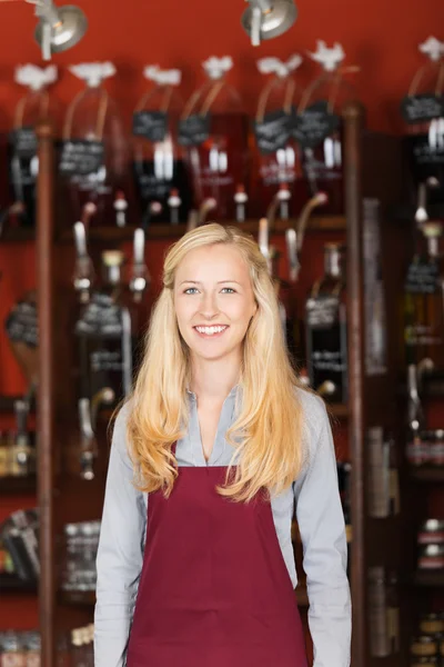 Cheerful saleswoman standing in store — Stock Photo, Image