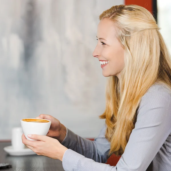 Cheerful blonde woman enjoying cappuccino — Stock Photo, Image